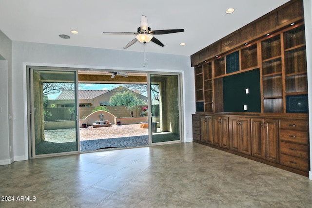 unfurnished living room featuring light tile floors and ceiling fan