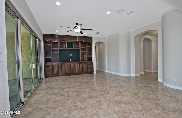 unfurnished living room with built in features, ceiling fan, and light tile floors