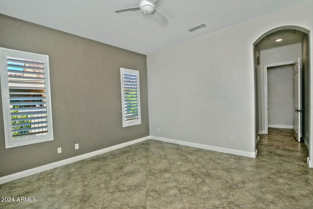 tiled empty room featuring ceiling fan