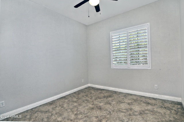 tiled empty room featuring ceiling fan