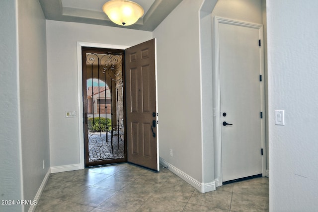 entrance foyer featuring light tile floors and a raised ceiling