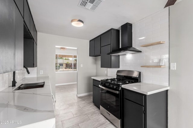 1010 W 5th Pl, Mesa, AZ 85201 - kitchen featuring black range with gas stovetop, wall chimney range hood, a sink, tasteful backsplash, and baseboards