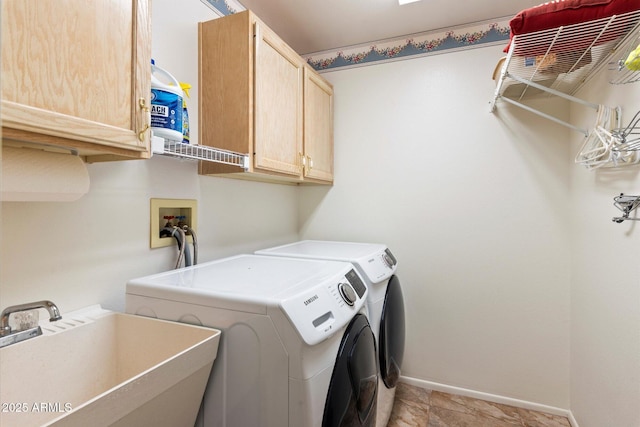 washroom featuring cabinets, washer and clothes dryer, and sink