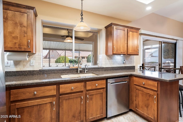 kitchen with sink, backsplash, hanging light fixtures, stainless steel dishwasher, and ceiling fan