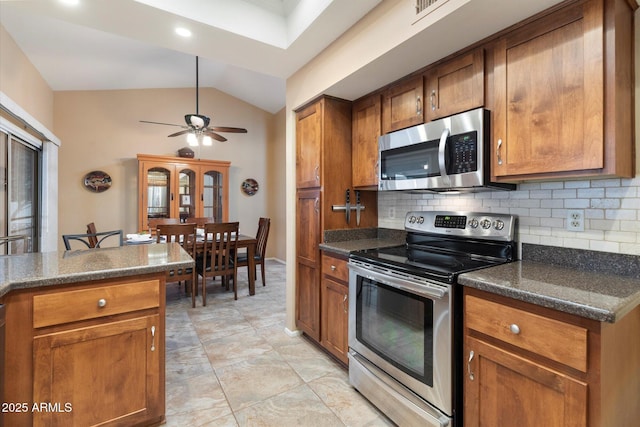 kitchen with tasteful backsplash, vaulted ceiling, stainless steel appliances, and ceiling fan