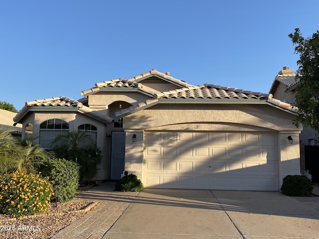 1417 E Century Ave, Gilbert, AZ 85296 - mediterranean / spanish house featuring an attached garage, driveway, a tile roof, and stucco siding