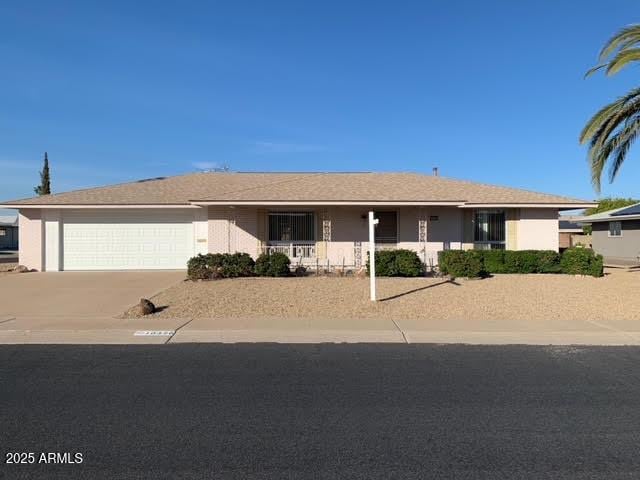 ranch-style home with concrete driveway, an attached garage, and stucco siding