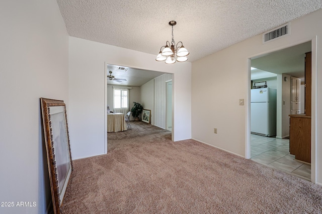 10326 W Pleasant Valley Rd, Sun City, AZ 85351 - unfurnished dining area featuring a textured ceiling, light tile patterned flooring, light carpet, ceiling fan with notable chandelier, and visible vents