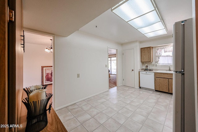 10326 W Pleasant Valley Rd, Sun City, AZ 85351 - kitchen featuring white dishwasher, light countertops, a wealth of natural light, and freestanding refrigerator