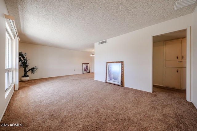 10326 W Pleasant Valley Rd, Sun City, AZ 85351 - carpeted empty room featuring a notable chandelier, visible vents, and a textured ceiling