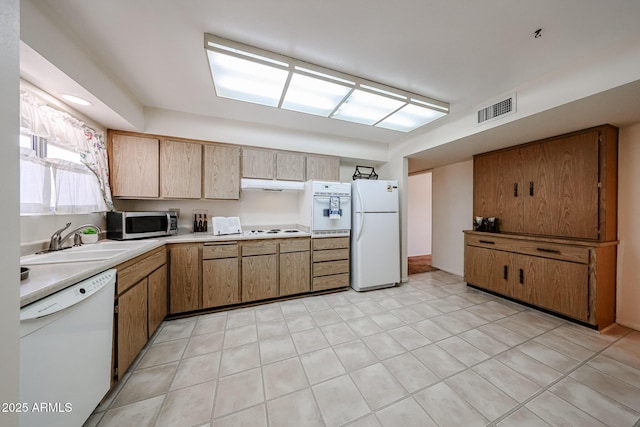 10326 W Pleasant Valley Rd, Sun City, AZ 85351 - kitchen featuring white appliances, a sink, visible vents, light countertops, and brown cabinets