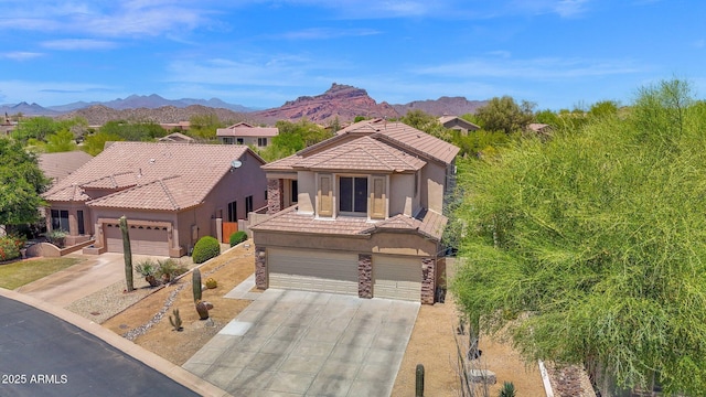 7260 E Tasman St, Mesa, AZ 85207 - view of front of home with stucco siding, a tiled roof, concrete driveway, a mountain view, and stone siding