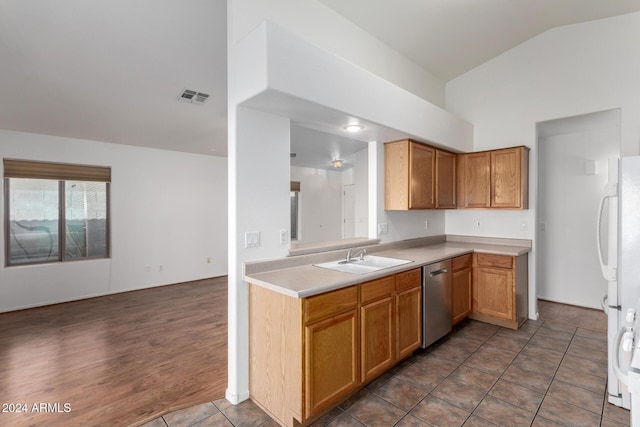 kitchen with dishwasher, sink, white refrigerator, vaulted ceiling, and dark tile patterned flooring