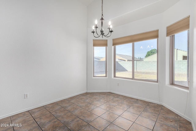 tiled empty room featuring a chandelier