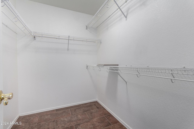 spacious closet featuring dark tile patterned flooring