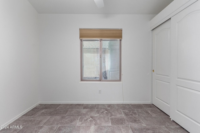 unfurnished bedroom featuring ceiling fan and a closet