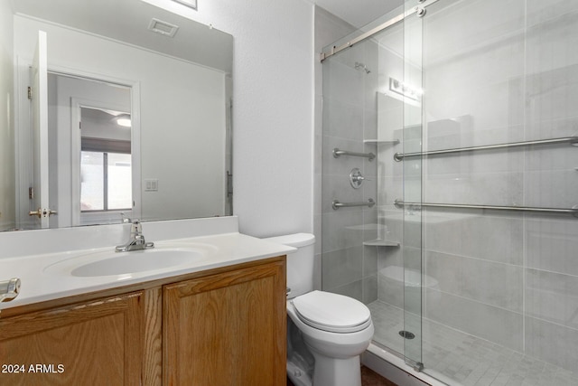 bathroom with toilet, vanity, and walk in shower