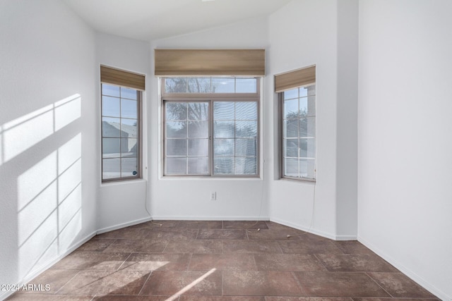 unfurnished room featuring lofted ceiling