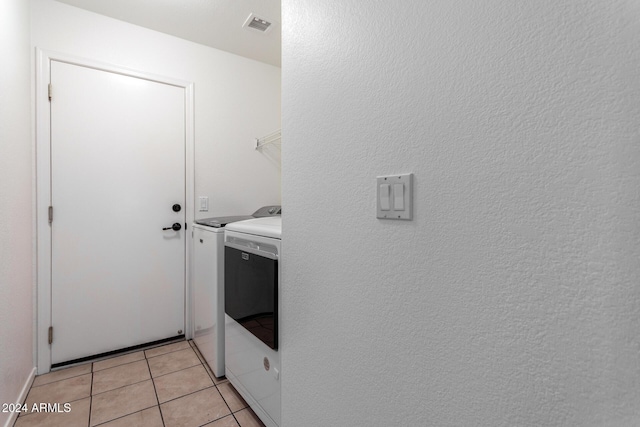 washroom with washer and dryer and light tile patterned flooring