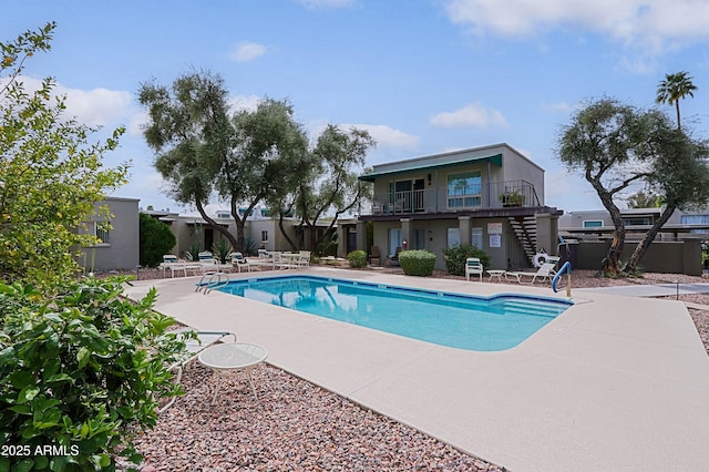 pool with a patio area and fence