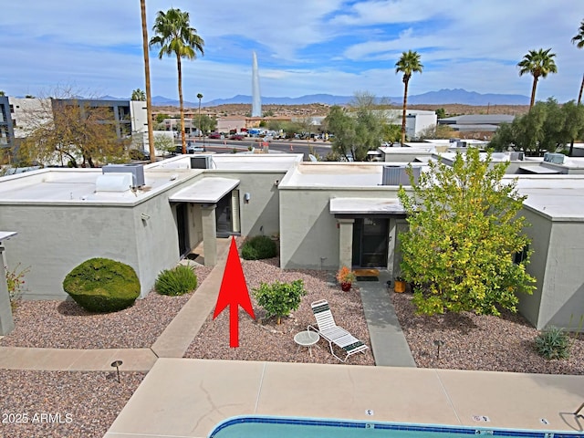 exterior space with a mountain view and stucco siding