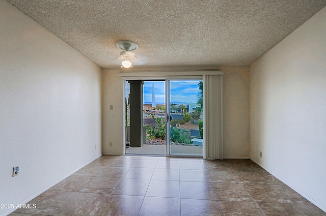 spare room with a textured ceiling and baseboards