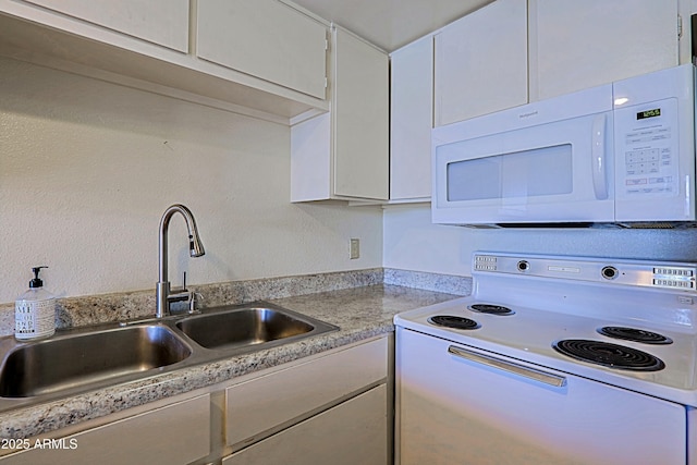 kitchen featuring light countertops, white appliances, a sink, and white cabinetry