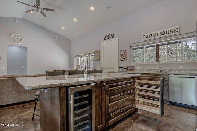 kitchen featuring wine cooler, a kitchen island, ceiling fan, a kitchen bar, and dishwasher