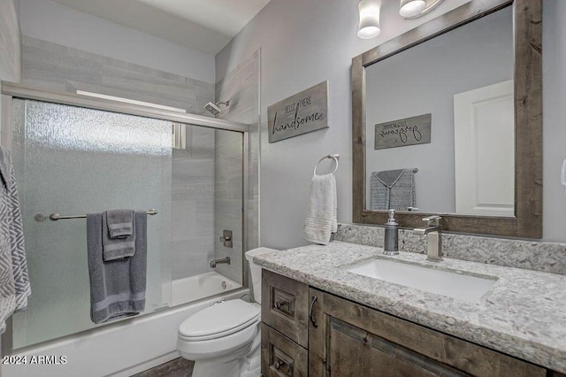 full bathroom featuring vanity, toilet, and combined bath / shower with glass door