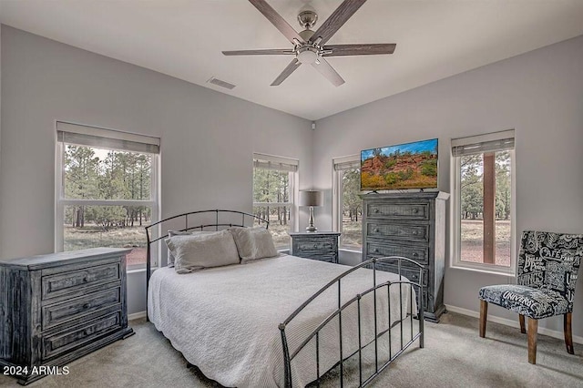 bedroom with ceiling fan, multiple windows, and light colored carpet