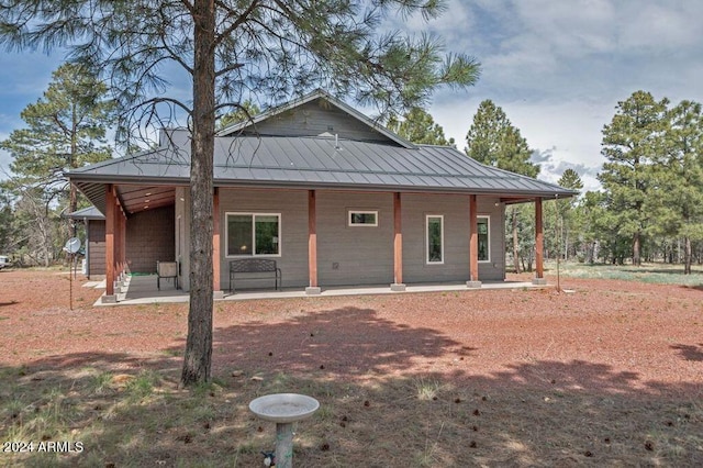 rear view of house featuring covered porch