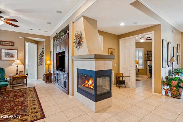 living room featuring light tile patterned floors, crown molding, and a fireplace