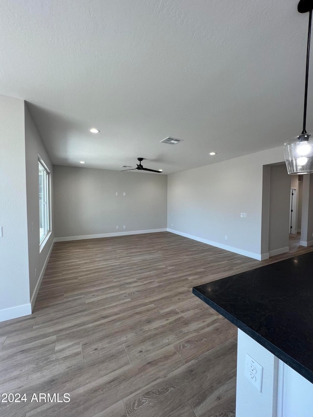 unfurnished living room with hardwood / wood-style floors and ceiling fan