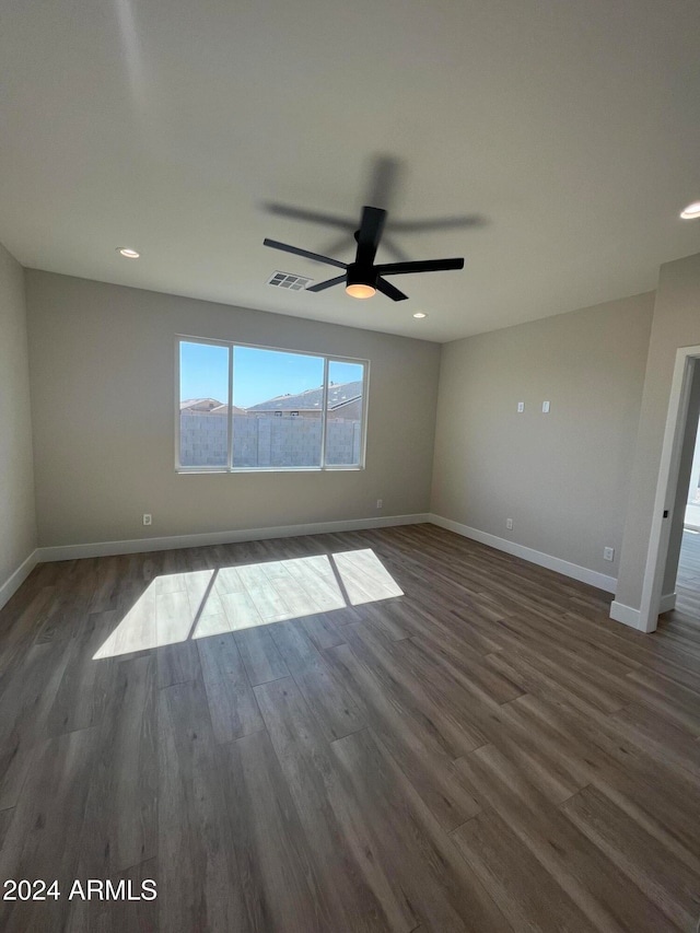 unfurnished room with a mountain view, dark hardwood / wood-style floors, and ceiling fan