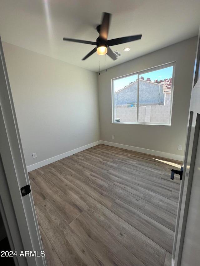 spare room with ceiling fan and light wood-type flooring