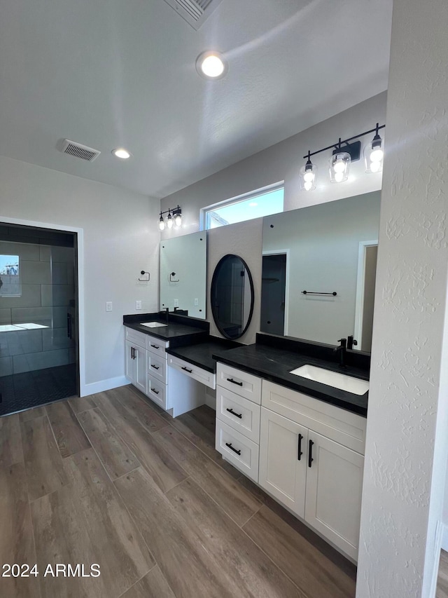 bathroom with vanity, wood-type flooring, and walk in shower