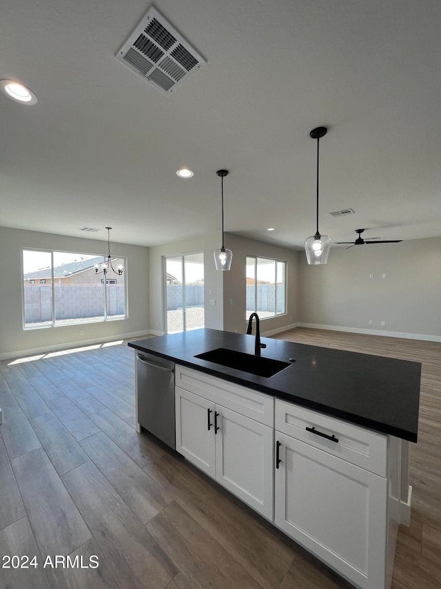 kitchen featuring dishwasher, sink, pendant lighting, white cabinets, and light hardwood / wood-style floors