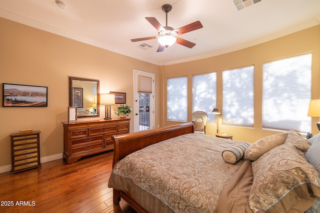 bedroom with crown molding, wood-type flooring, and ceiling fan