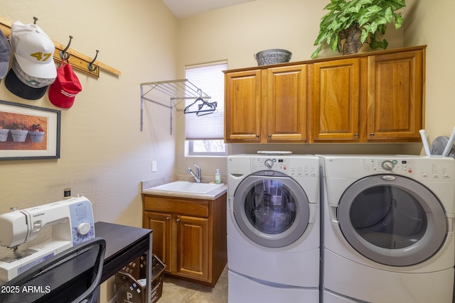 laundry area featuring cabinets, sink, and washer and clothes dryer