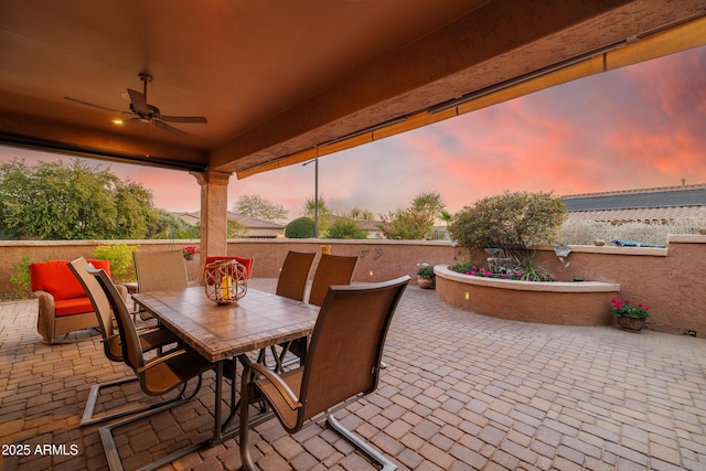 patio terrace at dusk featuring ceiling fan