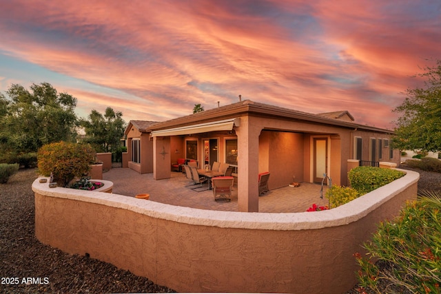 back house at dusk with a patio area and an outdoor fire pit