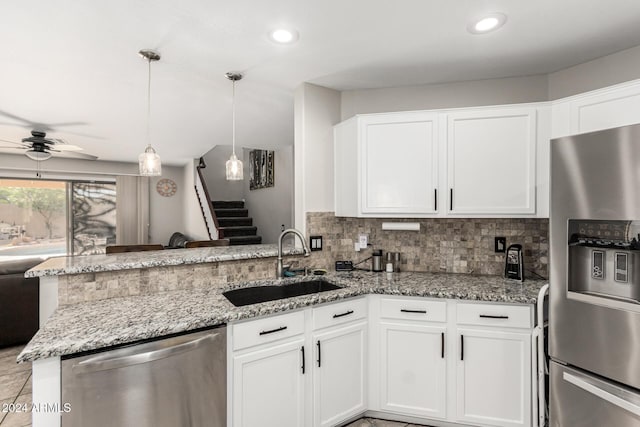 kitchen with kitchen peninsula, appliances with stainless steel finishes, ceiling fan, sink, and white cabinets