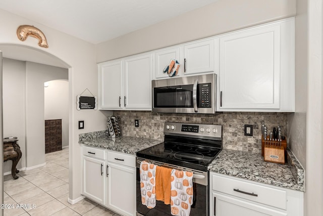 kitchen featuring white cabinets, light tile patterned floors, stainless steel appliances, and light stone counters