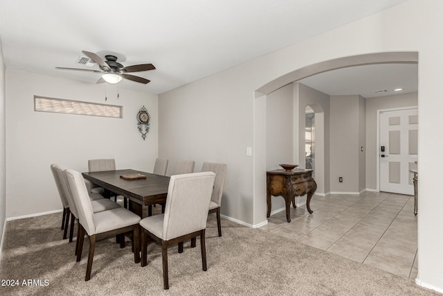 carpeted dining space with ceiling fan