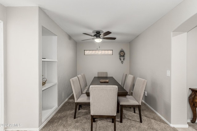 carpeted dining area with ceiling fan