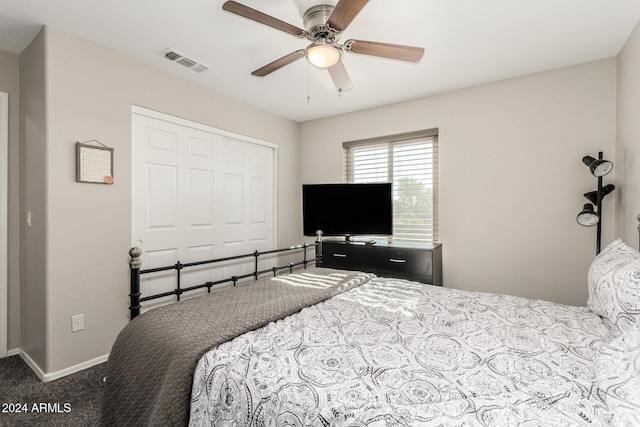 carpeted bedroom featuring ceiling fan and a closet