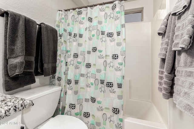 bathroom featuring shower / bathtub combination with curtain and toilet