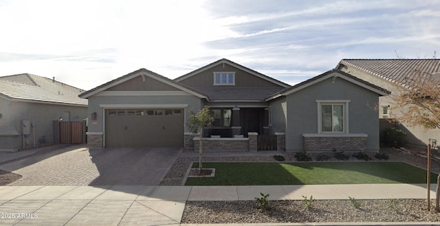 craftsman house featuring fence, a porch, stucco siding, a garage, and decorative driveway