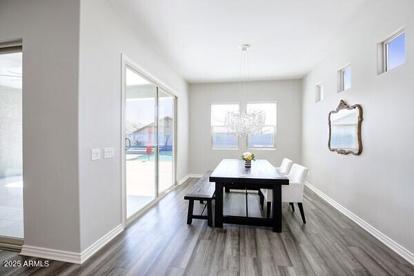 dining room with baseboards, an inviting chandelier, and wood finished floors