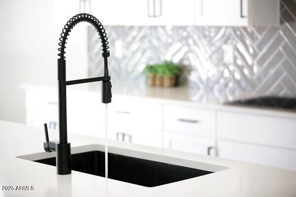 details featuring white cabinets, light countertops, and a sink